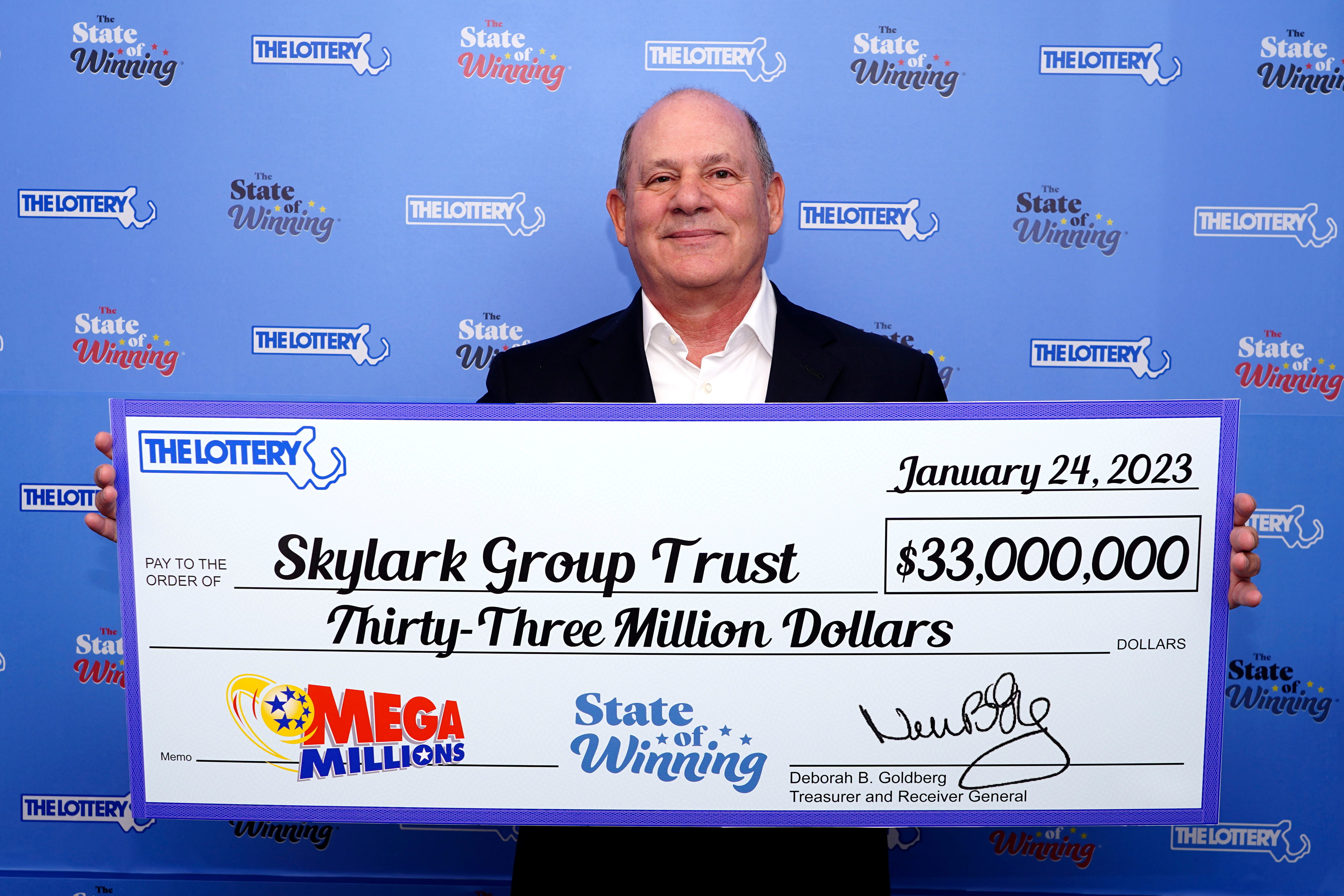 Senhor segurando cheque de prêmio da Mega Millions